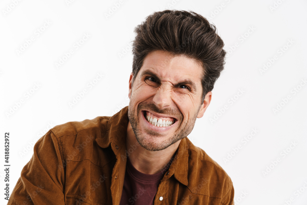 Angry handsome young man grimacing and looking at camera Angry handsome young man grimacing and looking at camera