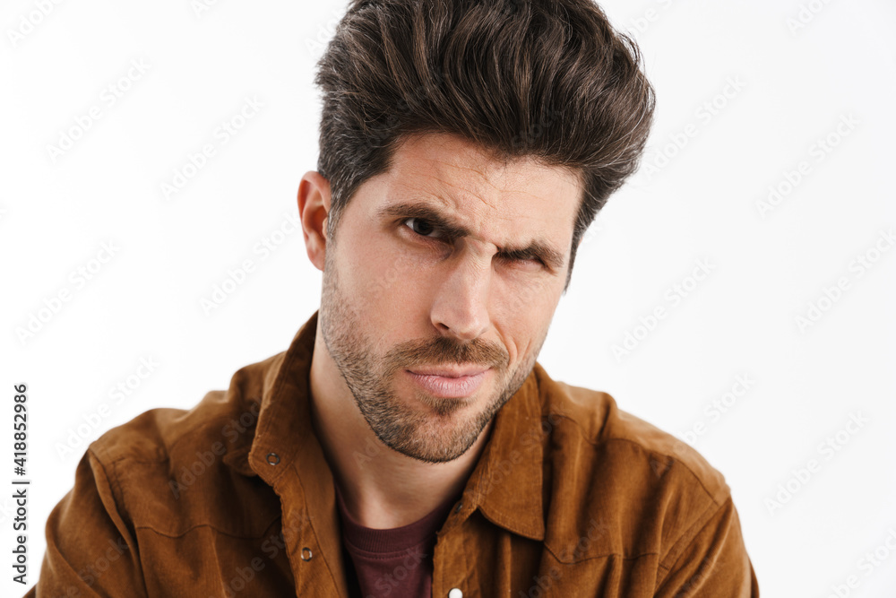 Brooding young unshaven man posing and looking at camera Brooding young unshaven man posing and looking at camera