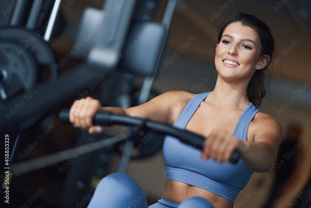 Fototapeta premium Adult woman working out in a gym