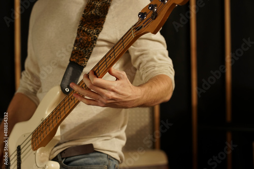 The guy plays the bass guitar. Bass guitarist holds an electric guitar in his hands and plays on it