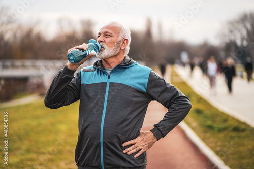 Active senior man is drinking water after exercising. Healthy lifestyle.