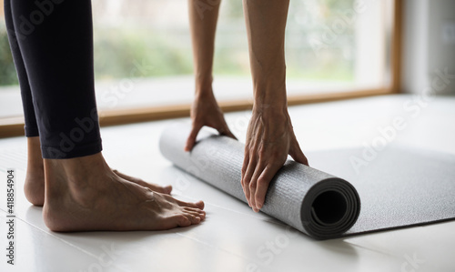 Woman rolling up exercise mat after doing yoga or fitness closeup banner. Training, fitness, workout, meditation, yoga class, self-care, relaxation, pilates, healthy lifestyle, recreation concept.