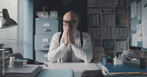 Foto Worried stressed businessman sitting in the office