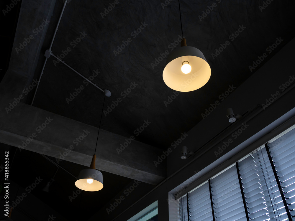 Modern round ceiling light with light bulb hanging from concrete construction. Modern round ceiling light with light bulb hanging from concrete construction.