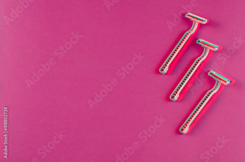 Pink plastic razors on a pink background with split glitch effect.