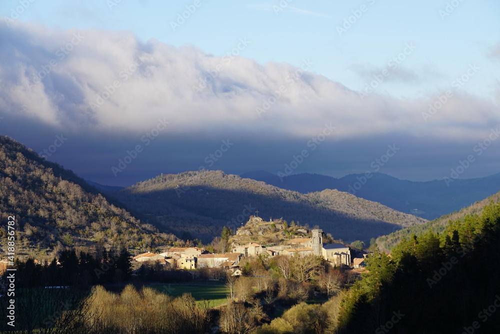 stormy sky on the village on the hill with view of the mountains in the Pyrénées, France