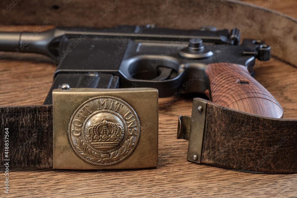 Obraz premium Deutsches Koppel aus dem 1. Weltkrieg (1914-1918) auf rustikalem alten Holz, im Hintergrund eine alte Mauser Pistole