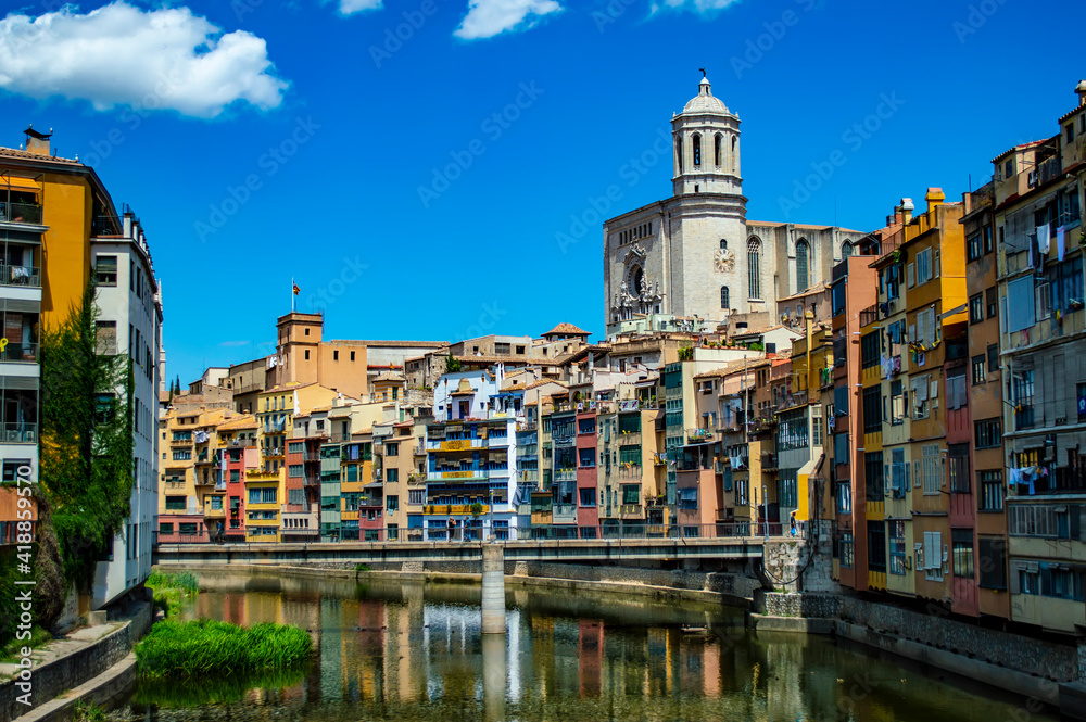 Girona, Spain - July 28, 2019: Saint Mary Cathedral and colorful riverside houses of the Jewish quarter in the city of Girona, Catalonia, Spain