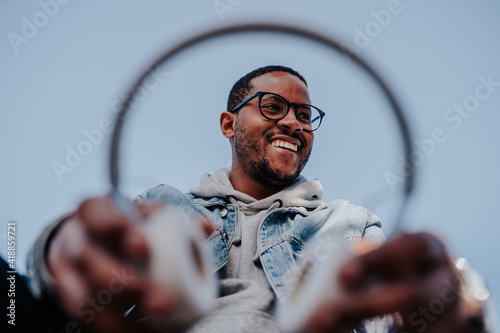 black boy in park listening to music with headphones