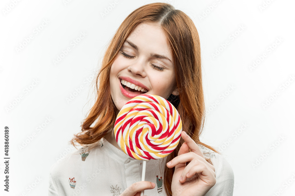 red-haired woman with a round lollipop in her hands emotions joy sweets candy