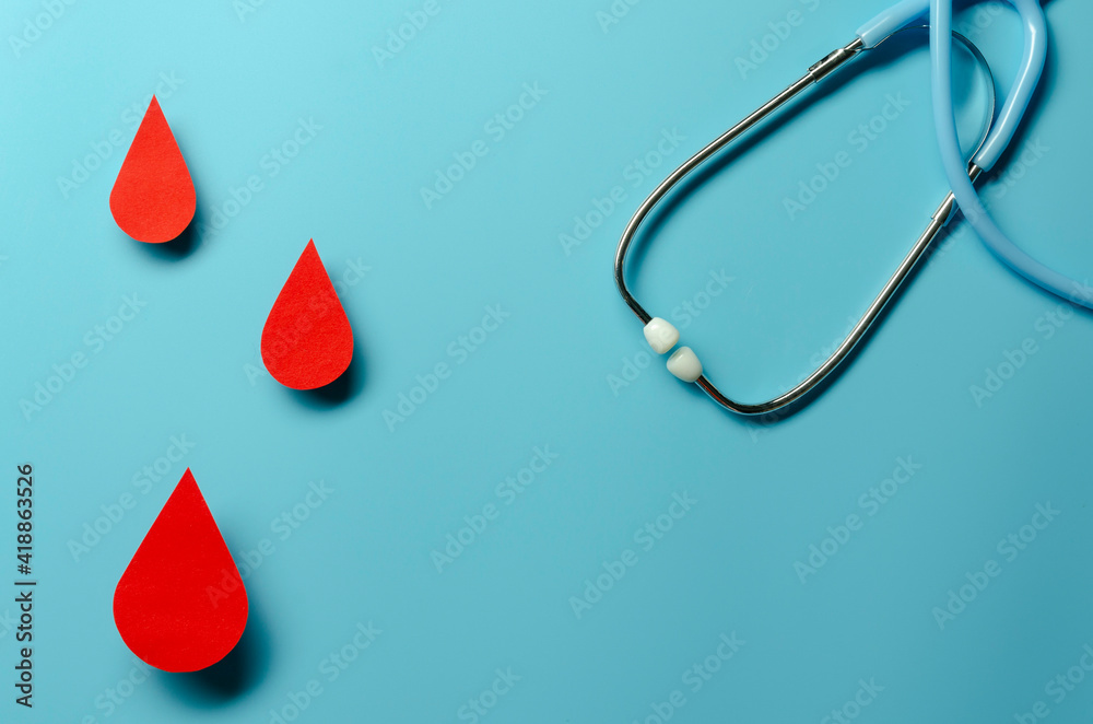 Fototapeta premium Blood drop symbol on blue background. Hemophilia day, blood donor day.