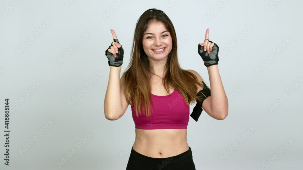 Young caucasian woman with sports clothes pointing a great idea and looking up over isolated background Young caucasian woman with sports clothes pointing a great idea and looking up over isolated background