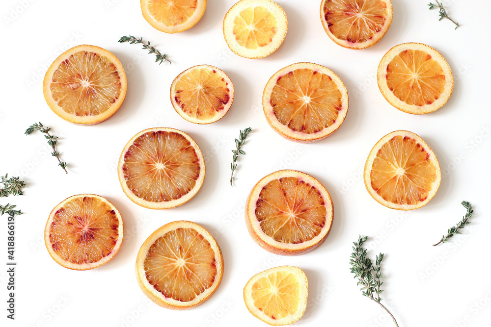 Close-up of fresh whole and slice cut bloody oranges with thyme herb isolated on white table backgrounds. Fruit pattern. Food concept. Summer frame, web banner. Flat lay, top Close-up of fresh whole and slice cut bloody oranges with thyme herb isolated on white table backgrounds. Fruit pattern. Food concept. Summer frame, web banner. Flat lay, top