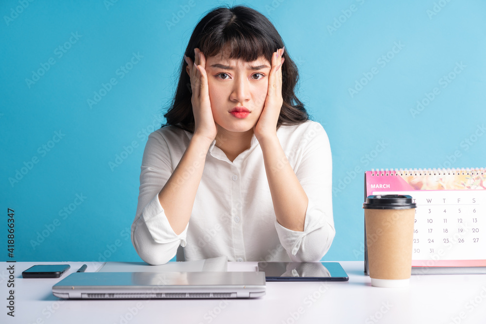 Fototapeta premium Young Asian buisness woman working on blue background