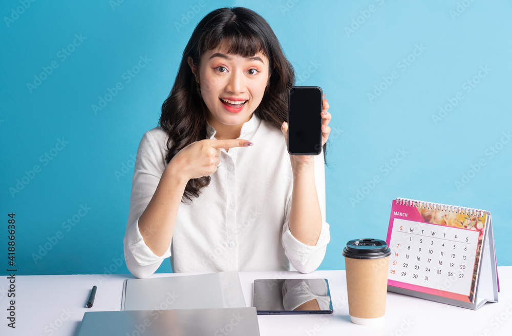 Young Asian buisness woman working on blue background Young Asian buisness woman working on blue background