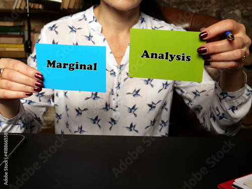 Hand holding green and blue business cards with phrase Marginal Analysis . photo