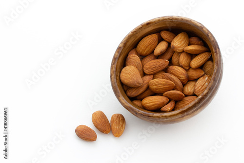 bamboo bowl of almonds on white background