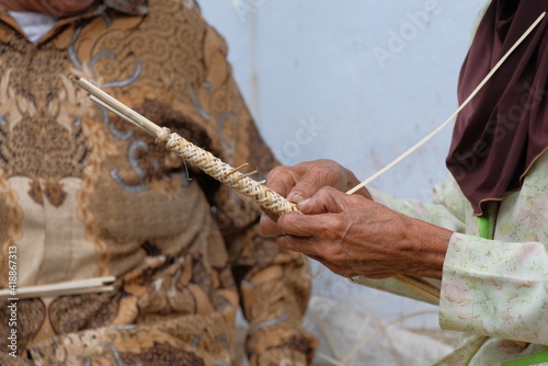 close and details of hand on making process of traditional whip or pecut photo