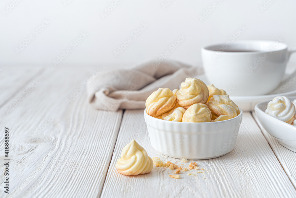 A cup with yellow meringues on a white background. A cup with yellow meringues on a white background.