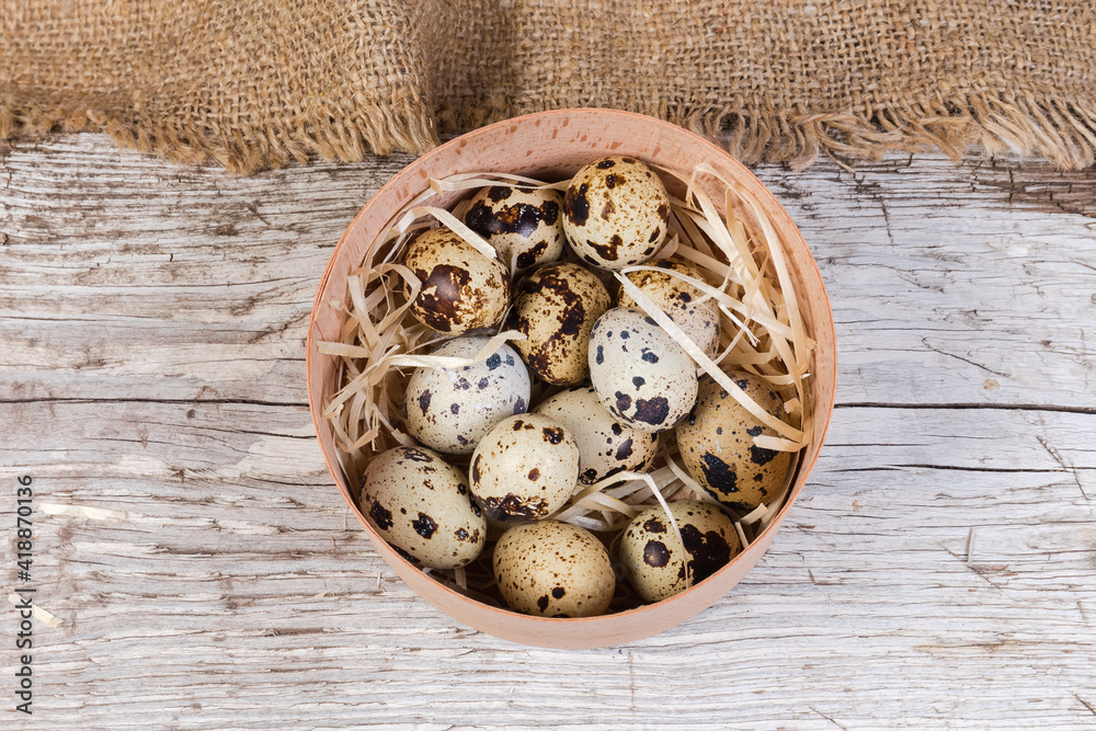 Quail eggs in wooden box on wooden surface, top view Quail eggs in wooden box on wooden surface, top view