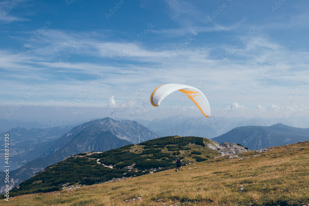 Detail to start of parachutist and gather necessary pressure and wind into his parachute so he can soar into clouds and enjoy flight over Krippenstein Mountain overlooking Dachstein and Hallstattsee Detail to start of parachutist and gather necessary pressure and wind into his parachute so he can soar into clouds and enjoy flight over Krippenstein Mountain overlooking Dachstein and Hallstattsee
