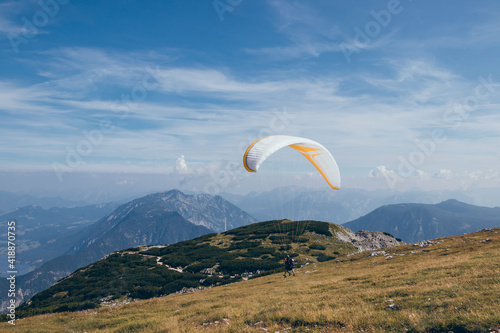 Detail to start of parachutist and gather necessary pressure and wind into his parachute so he can soar into clouds and enjoy flight over Krippenstein Mountain overlooking Dachstein and Hallstattsee