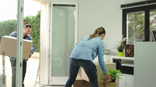 happy young couple moving carboard boxes and furnitures during move into a new home flat apartment photo