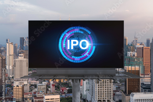 IPO icon hologram on road billboard over sunset panorama city view of Kuala Lumpur. KL is the hub of initial public offering in Malaysia, Asia. The concept of exceeding business opportunities.