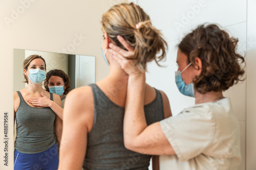 Physiotherapist and patient in Global Postural correction session, with pandemic protection mask.