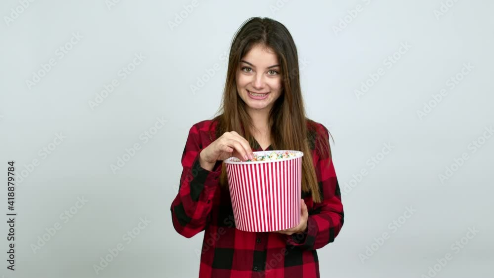 Young caucasian woman eating popcorns in a big bowl over isolated background Young caucasian woman eating popcorns in a big bowl over isolated background