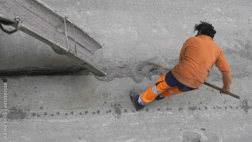 worker pours colored concrete that is poured from a truck mixer to fill the cable where the optical fiber ducts are housed