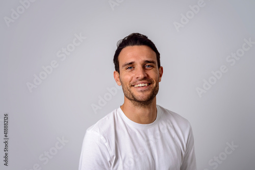 Portrait of a cheerful man in a white T-shirt smiling to the camera