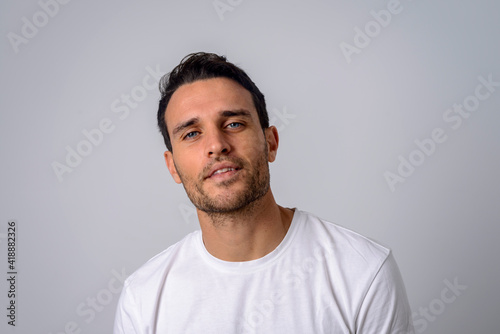 Portrait of a handsome man in a white T-shirt looking to the camera