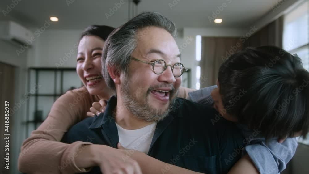 Portrait of overjoyed cheerful mature dad father have fun with excited little cute boy children at home, happy dad play engaged in funny activity with mom and kid on holiday in living room