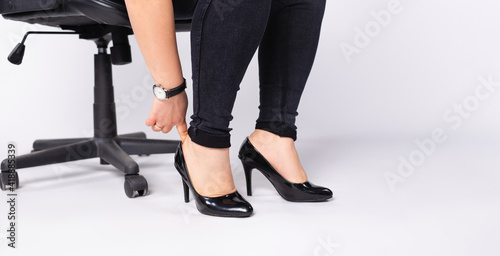 Banner,long format. Women's plump legs in black shoes on a white background with space for text or advertising of women's shoes.