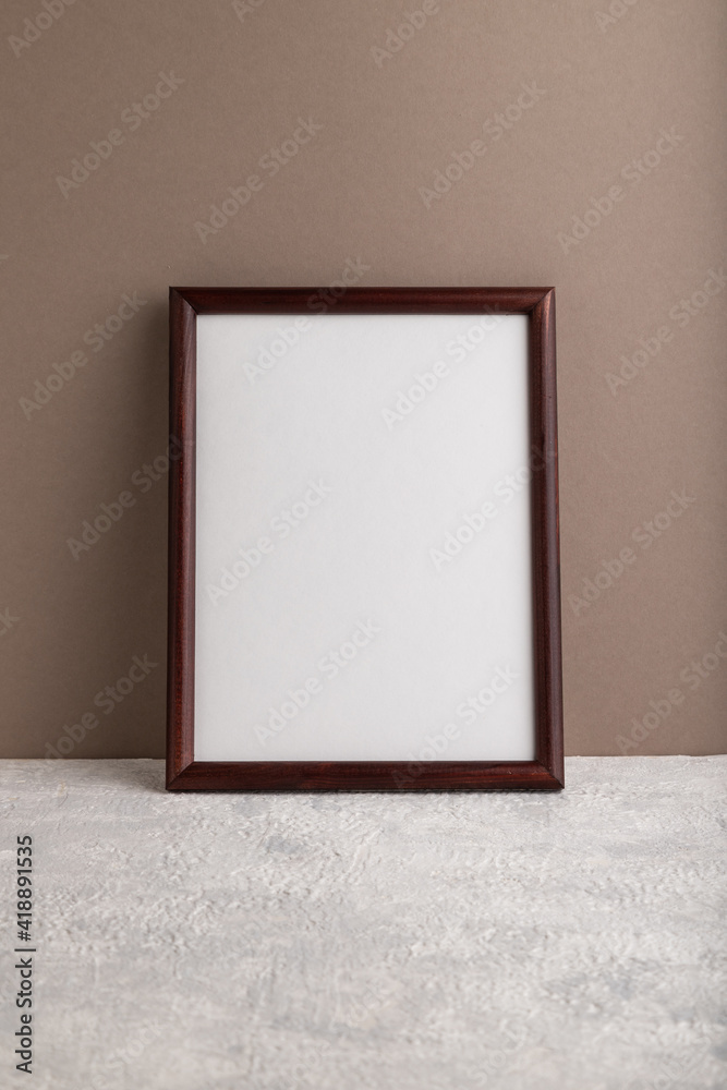 Brown wooden frame mockup on beige paper background. Blank, vertical orientation, still life. - obrazy, fototapety, plakaty 