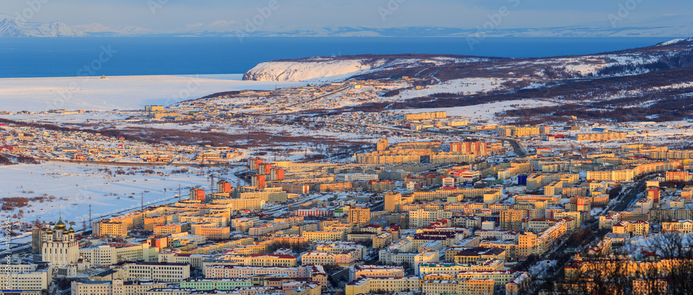 Beautiful aerial panorama of the city of Magadan. Top view of a large northern city. Sea bay and mountains in the distance. Magadan, Magadan Region, Far East of Russia. Siberia. Panoramic cityscape.