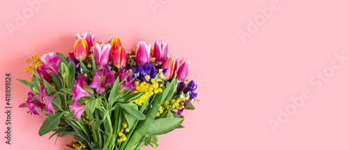Fototapeta Naklejka Na Ścianę i Meble -  A bouquet of bright spring flowers on a pastel pink background. Banner. Floral texture. Valentines background. Copy space, top view