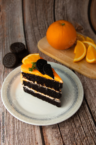 Orange chocolate cakeon a plate with orange fruit commuter. photo