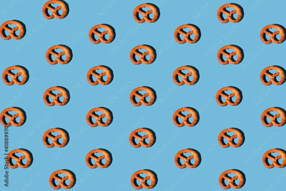pattern of pretzels on a blue background properly arranged with a sharp light. minimal flat lay aesthetic pattern of pretzels on a blue background properly arranged with a sharp light. minimal flat lay aesthetic