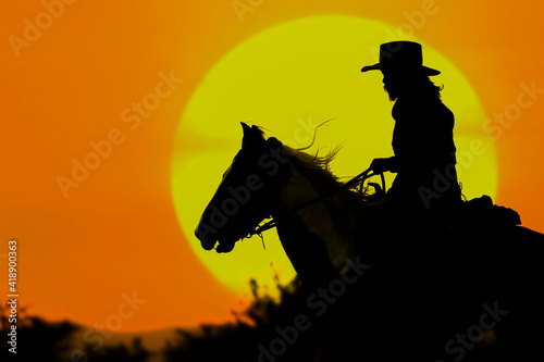 The silhouette of the cowboy and the setting sun