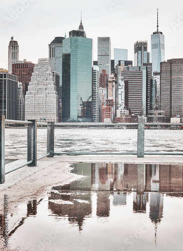 Manhattan skyline with reflection in a puddle  color toning applied  New York City  USA.