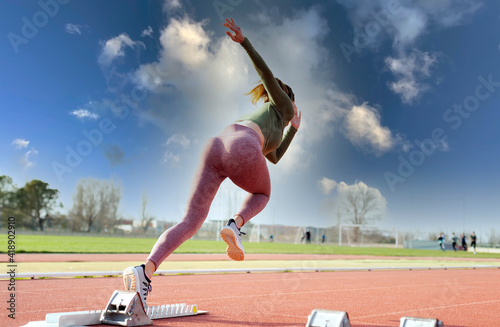 Sprinter taking off from starting block on running track 