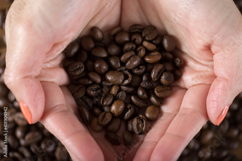 Woman with roasted coffee beans in her hands.