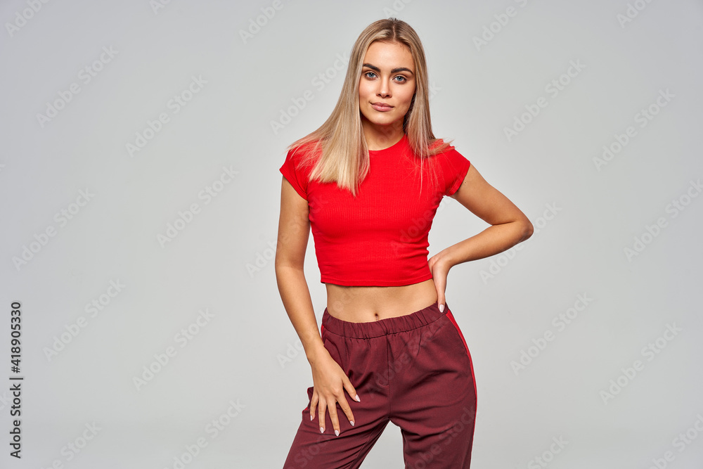 Sexy blonde woman wear of sport suit isolated on gray background Sexy blonde woman wear of sport suit isolated on gray background