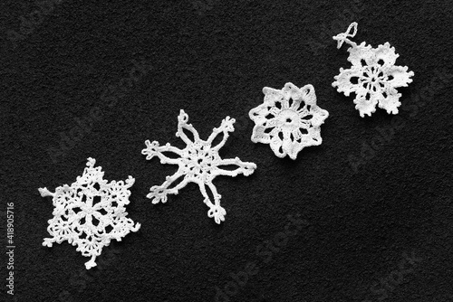 Knitting. Decoration in the form of snowflakes in various combinations on a black background