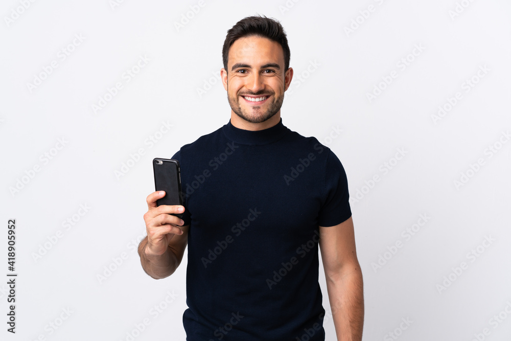 Young caucasian man using mobile phone isolated on white background smiling a lot Young caucasian man using mobile phone isolated on white background smiling a lot