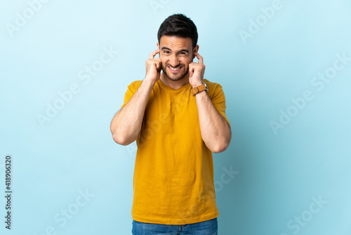 Young handsome man over isolated background frustrated and covering ears