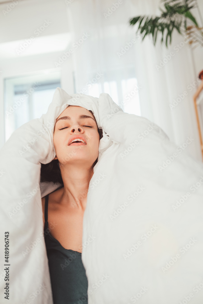 Brunette girl sitting on the bed and demonstrating her smile and emotions Brunette girl sitting on the bed and demonstrating her smile and emotions