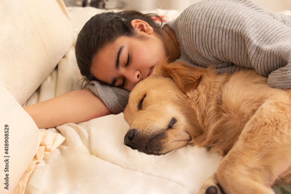 A PET DOG AND TEENAGER SLEEPING TOGETHER ON BED A PET DOG AND TEENAGER SLEEPING TOGETHER ON BED